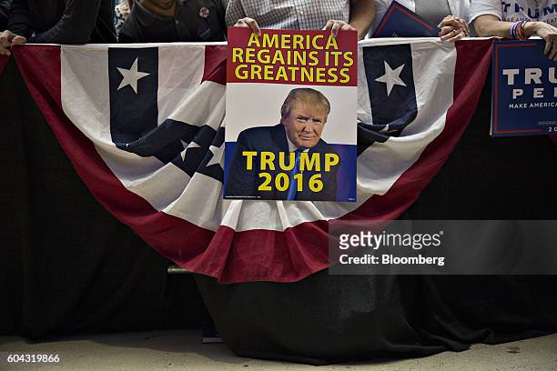 Attendees hold signs while waiting for the start of a campaign event with Donald Trump, 2016 Republican presidential nominee, in Des Moines, Iowa,...