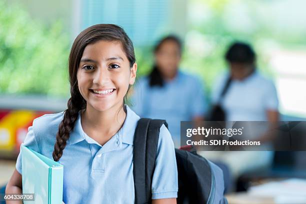 confident hispanic middle schoolgirl before class - schooluniform stockfoto's en -beelden
