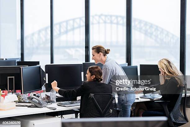 professionelle geschäftsfrauen im australischen büro, die an computern arbeiten - australia technology stock-fotos und bilder