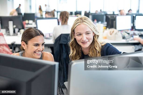 two women working in office looking at computer, smiling - aboriginal australian ethnicity stock pictures, royalty-free photos & images