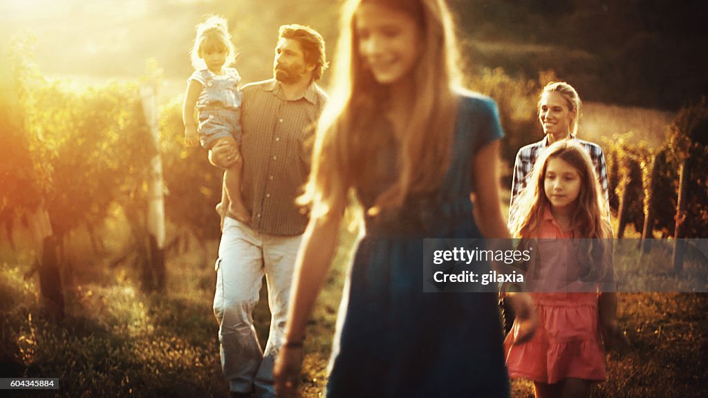 Familia caminando por un viñedo.