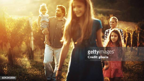 family walking through a vineyard. - brown hair drink wine stock pictures, royalty-free photos & images