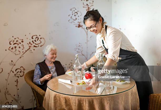 waitress brings foods to customers - chinese waiter stock pictures, royalty-free photos & images