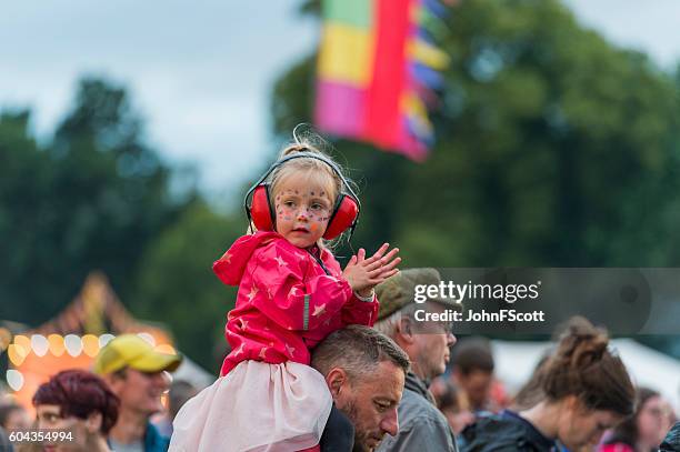 child wearing ear defenders at a scottish music festival - oorbeschermer stockfoto's en -beelden