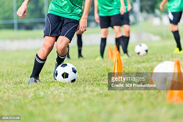 atleta di calcio partecipa alle esercitazioni di allenamento di calcio - calciare foto e immagini stock