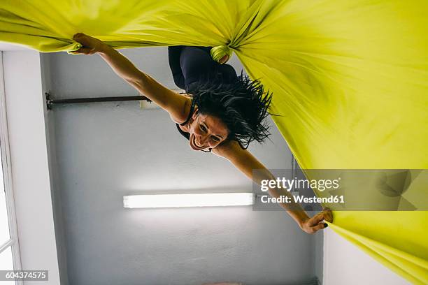 woman doing aerial silk dance hanging upside down from a silk cloth - silk draped stock pictures, royalty-free photos & images