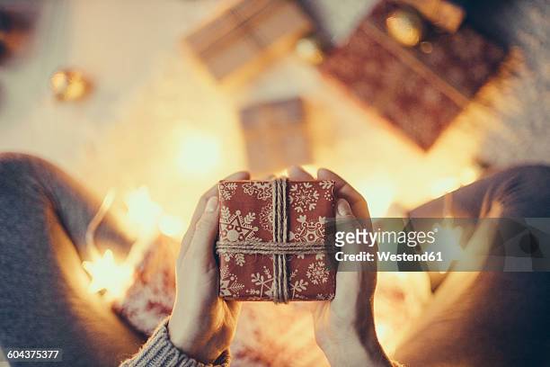 woman's hands holding christmas present - gift lounge stock-fotos und bilder