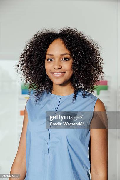 young woman standing in office - facial expression girl office stock-fotos und bilder