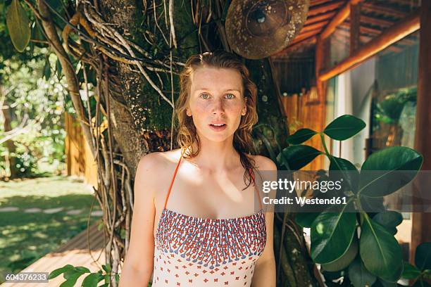 brazil, porto seguro, portrait of woman wearing bathing suit standing in front of a tree - porto seguro stock pictures, royalty-free photos & images