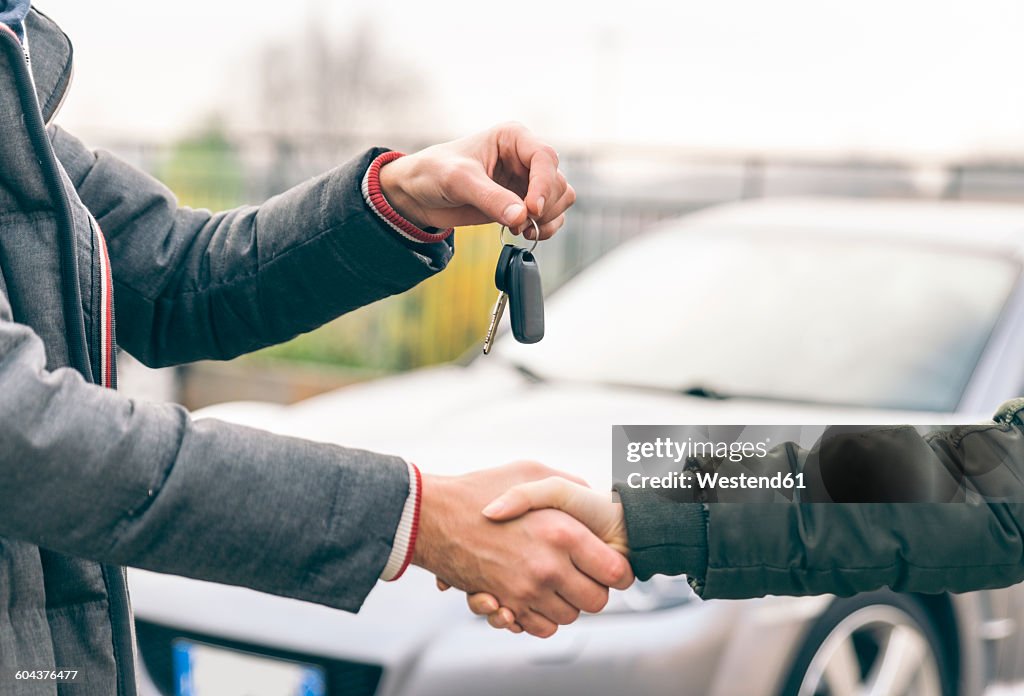 Two people reaching an agreement about a car sale