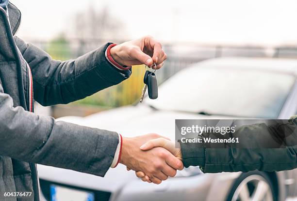 two people reaching an agreement about a car sale - car dealership imagens e fotografias de stock