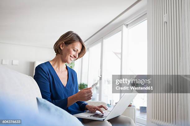 smiling woman at home shopping online - woman online shopping stock-fotos und bilder
