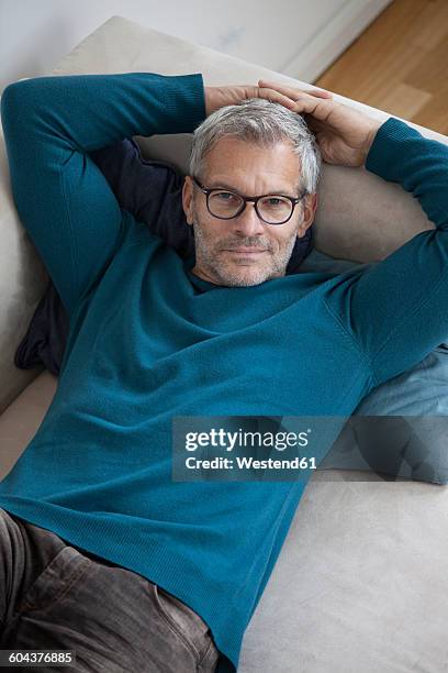 portrait of mature man at home lying on couch - 長袖 ストックフォトと画像