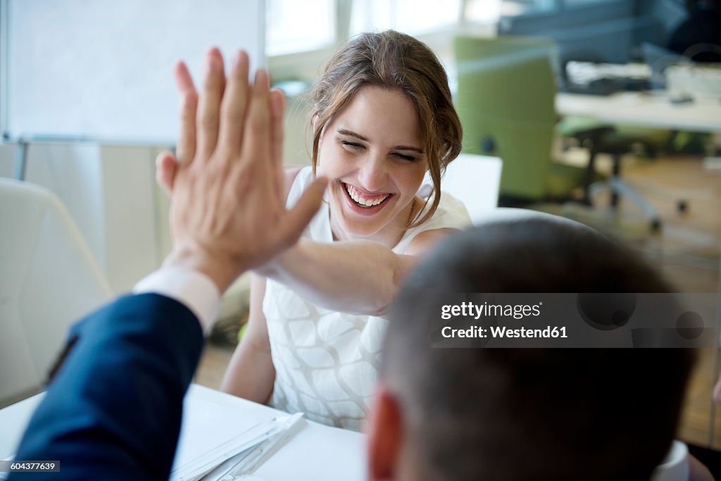 Happy businesswoman and businessman high fiving