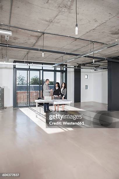 businesspeople standing and talking in new open office - makeshift office stock pictures, royalty-free photos & images