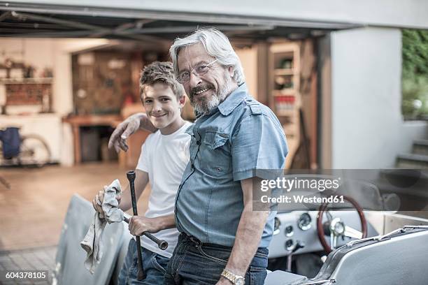 portrait of grandfather and grandson restoring a car together - restoring stock pictures, royalty-free photos & images