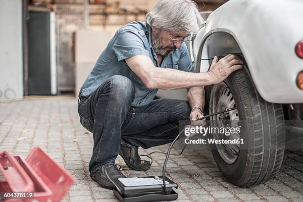 senior man at car measuring tire pressure - pressure gauge stock pictures, royalty-free photos & images