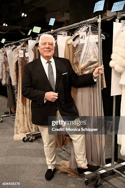 Designer Dennis Basso poses with his creations backstage at the Dennis Basso fashion show during New York Fashion Week: The Shows at The Arc,...