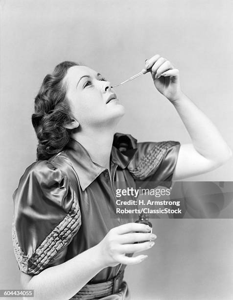 1940s WOMAN'S HEAD TILTED BACK USING GLASS EYE OR NOSE DROPPER