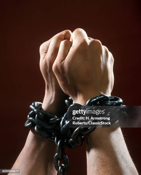 MAN'S HANDS FISTS TIED WITH CHAIN CHAINS PRISONER CHAINED CAPTIVE CRIMINAL CAUGHT PRISON CAPTURED