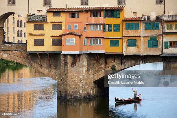 boat punted under ponte vecchio on river arno - ponte vecchio stock pictures, royalty-free photos & images