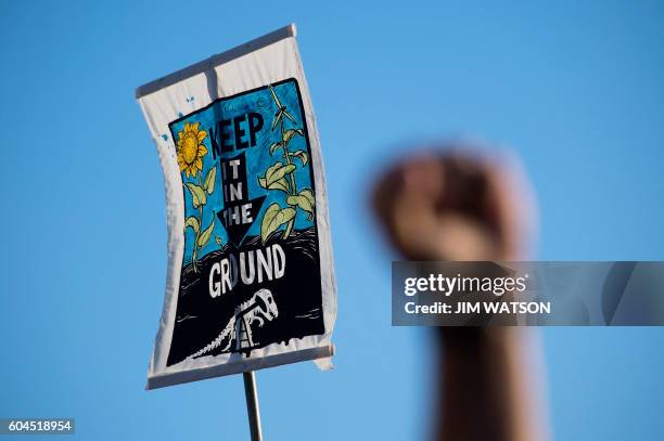 Demonstrator raises his first next to a placard as they gather in front of the White House in Washington, DC, September 13 to protest the Dakota...