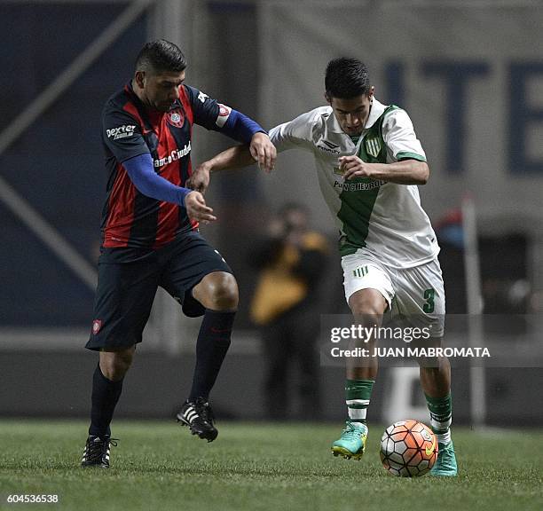 Argentina's Banfield defender Alexis Soto vies for the ball with Argentina's San Lorenzo midfielder Nestor Ortigoza during their Copa Sudamericana...