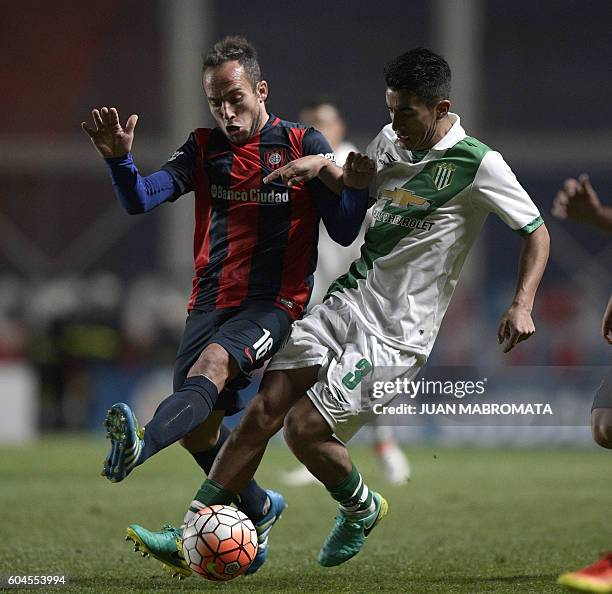 Argentina's Banfield defender Alexis Soto vies for the ball with Argentina's San Lorenzo midfielder Fernando Belluschi during their Copa Sudamericana...