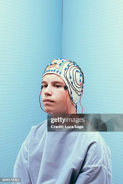 teenage boy wearing a brain testing cap - eeg stock-fotos und bilder