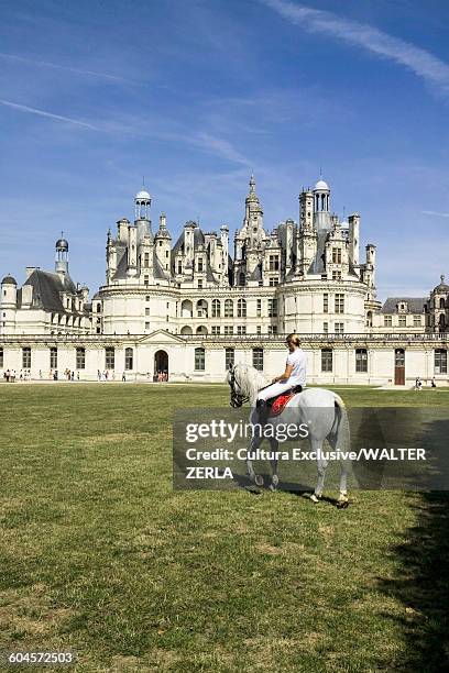 woman riding white horse in front of chateau de chambord, loire valley, france - chambord photos et images de collection