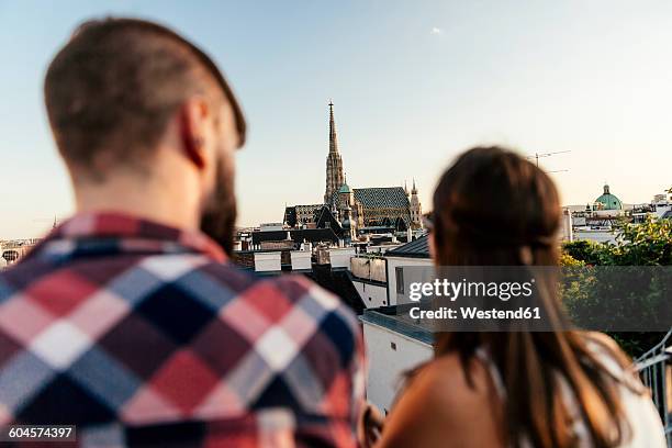 austria, vienna, back view of young couple on roof terrace looking at st. stephen's cathedral - stephansplatz stock pictures, royalty-free photos & images