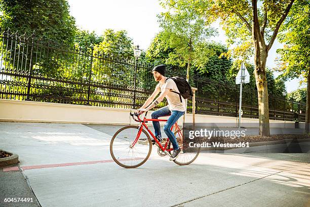 young man with racing cycle in vienna, dr.-karl-renner-ring - velofahren stock-fotos und bilder