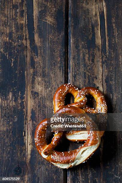 two pretzels on dark wood - brezel stock-fotos und bilder