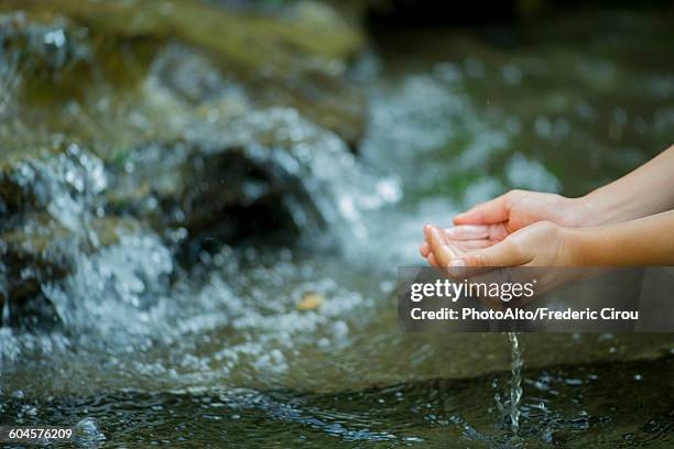hands scooping water from stream - wassersparen stock-fotos und bilder
