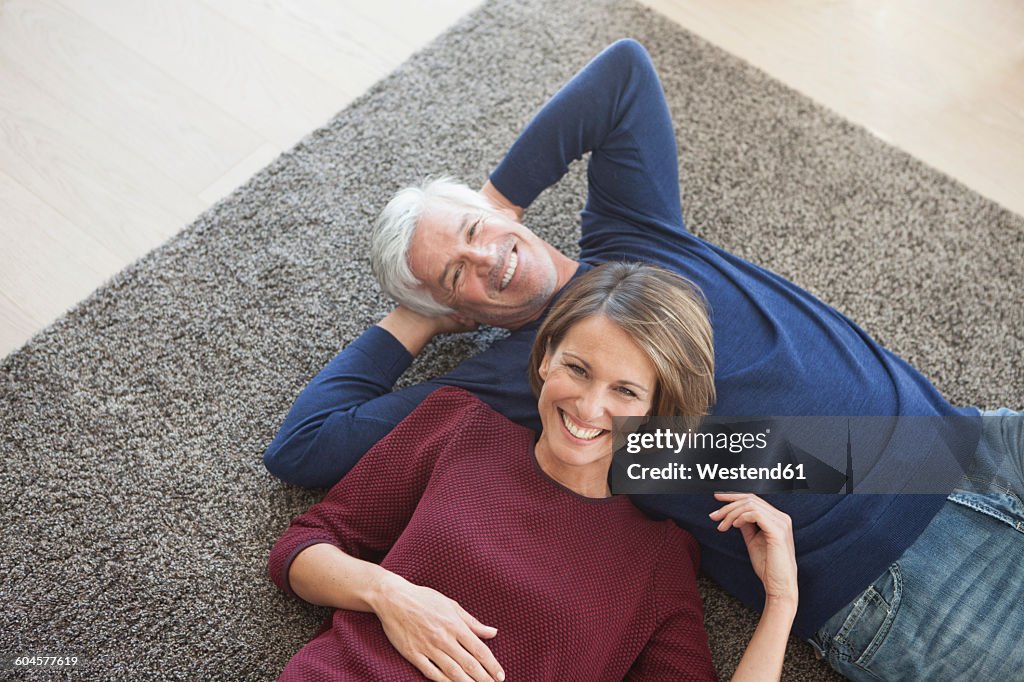 Happy couple relaxing together on the carpet