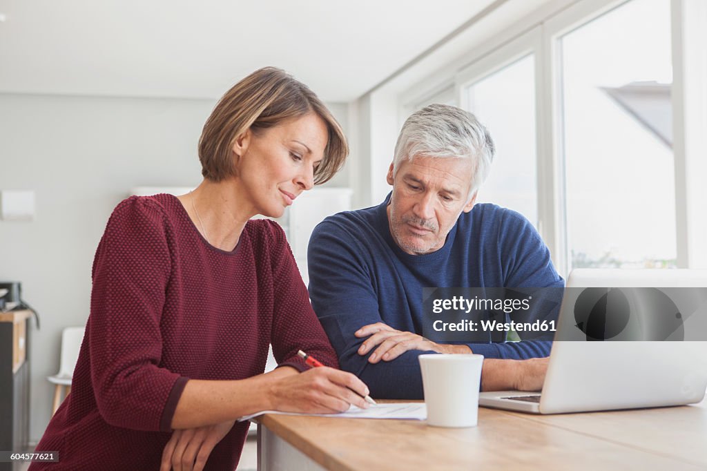 Couple using laptop at home