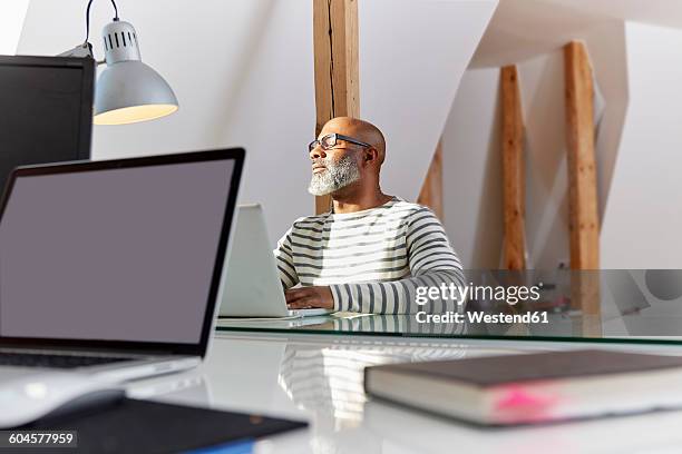 man with closed eyes sitting at his desk relaxing - roof beam stock pictures, royalty-free photos & images