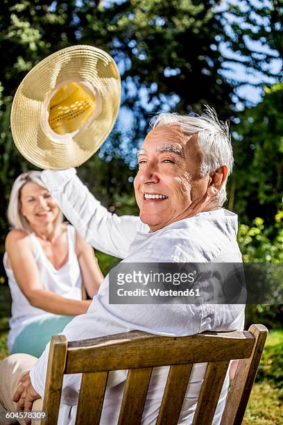 happy senior man in garden with woman in background - smiling woman on gray background 50 stock pictures, royalty-free photos & images