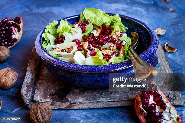 bowl of romaine lettuce with walnuts, pomegranate dressing and seed - bindsla stockfoto's en -beelden