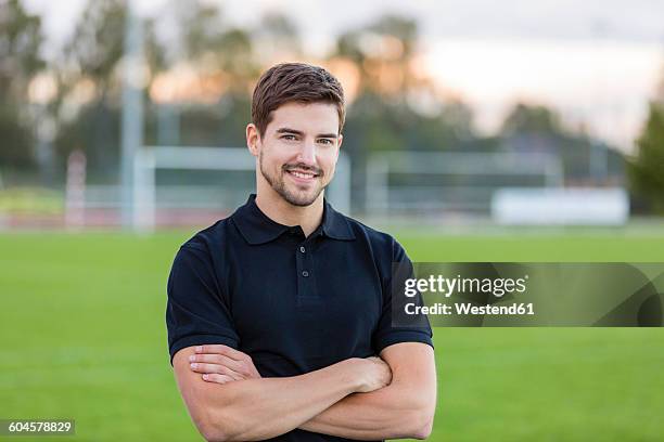 portrait of smiling man on sports field - football tee stock pictures, royalty-free photos & images