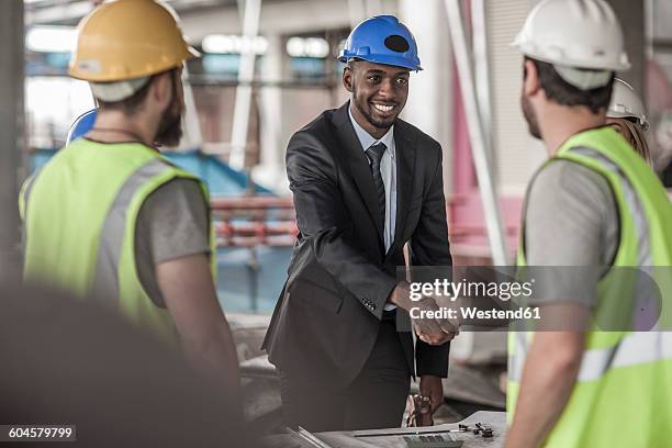 construction worker and executive shaking hands in construction site - suit maker stock pictures, royalty-free photos & images