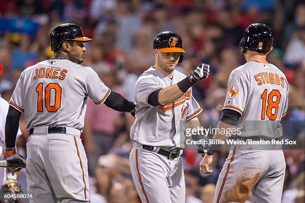 Nolan Reimold of the Baltimore Orioles celebrates with Adam Jones and Drew Stubbs on his two-run home run during the second inning of a game against...