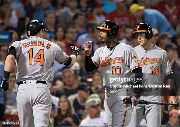 Nolan Reimold of the Baltimore Orioles is congratulated by Adam Jones and Drew Stubbs after hitting a home run against the Boston Red Sox in the...