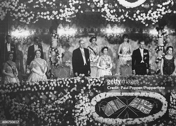 Queen Elizabeth II stands in the Royal Box with Princess Margaret, Queen Elizabeth the Queen Mother, President Charles de Gaulle of France, Prince...