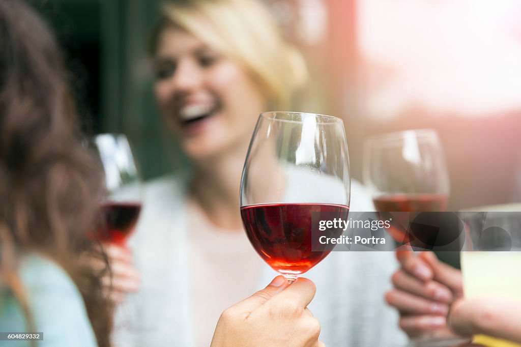Wineglass held by woman during social gathering