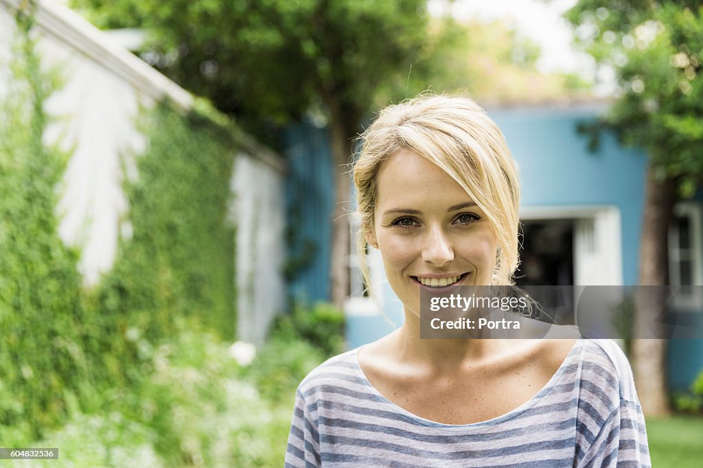 Confident young woman smiling in backyard