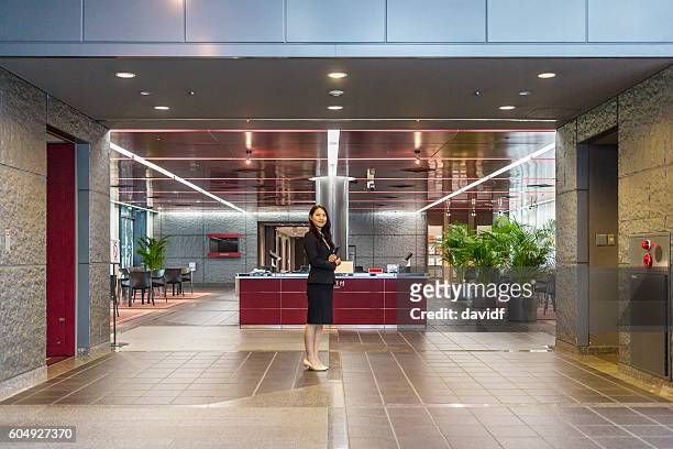 benvenuto professionale al business reception di women in office building - concierge foto e immagini stock