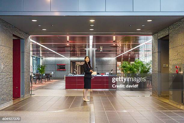 professional welcome at business reception by women in office building - concierge stock pictures, royalty-free photos & images