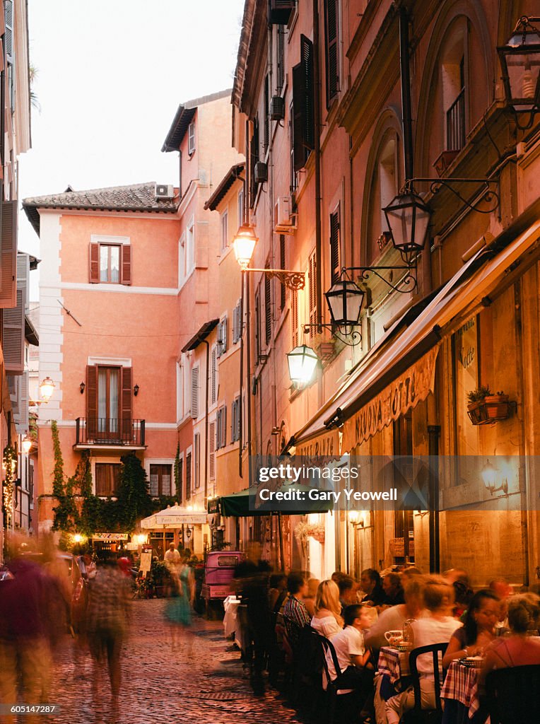 People dining outside restaurants at night