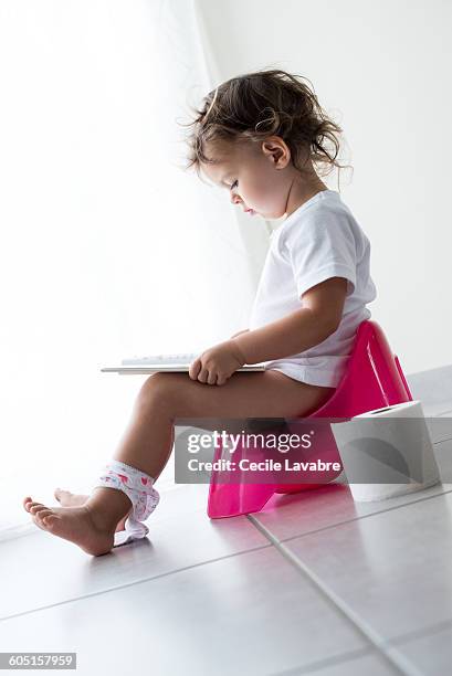 young girl reading on potty - girls peeing stock pictures, royalty-free photos & images